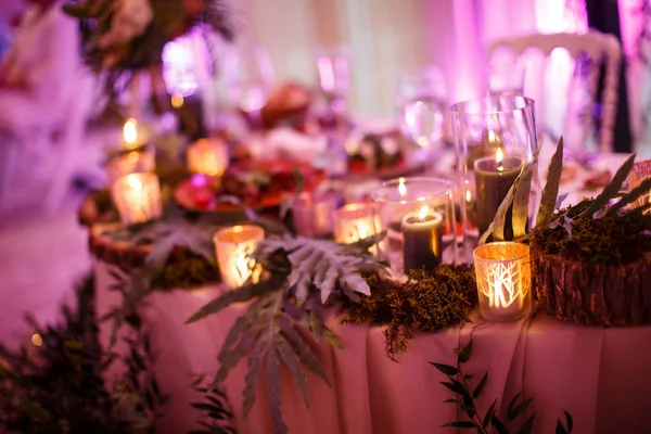 Un tavolo con tovaglia rosa e un mazzo di decorazioni in piedi su di esso . — Foto Stock