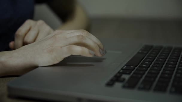 Пальцы молодой девушки, использующей ноутбук крупным планом. Она крутит тачпад и нажимает на клавиатуру. Передвижная камера . — стоковое видео
