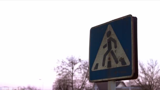 Een roestig voetgangers kruising teken. Een avondhemel is op de achtergrond. — Stockvideo