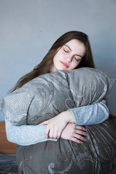 Kız uyuyor, yastığa sarılıyor, rüya görüyor.