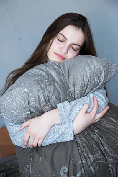 Kız uyuyor, yastığa sarılıyor, rüya görüyor.