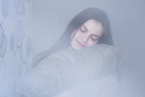 Kız uyuyor, yastığa sarılıyor, rüya görüyor.