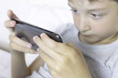 Cep telefonu, akıllı telefon aygıt oynayan genç bir çocuğun yüz expessions