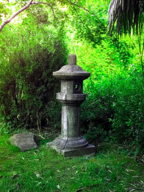 Japon fener Feng Shui tarzı yaprakların yeşil zemin üzerine taş