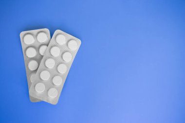 İki kopya alanı ile mavi arka plan üzerinde tıbbi hapları blister