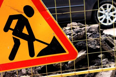 İşareti yol yapımı, yol bakım bir sarı kılavuz çit ve şehrin sokak çentikli asfalt yığını