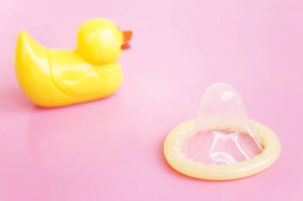 Contraceção Preservativo Aberto Brinquedo Amarelo Patinho Fundo Rosa Com Espaço — Fotografia de Stock