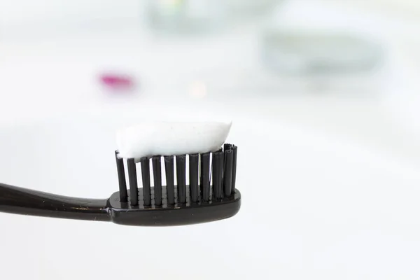 Black Toothbrush Toothpaste Blurred Bathroom Background — Stock Photo, Image