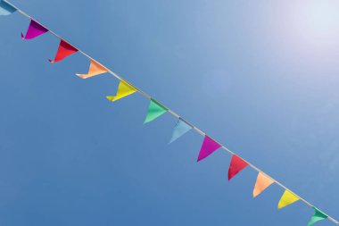 Gökyüzü arka plan üzerinde renkli bayraklar. kırmızı, sarı, mor, turuncu ve mavi renklerden bayrakları ile şerit. Parlak mavi gökyüzü, Festivali ile tatil için dışarı asılı ip üzerinde renkli bayrakları