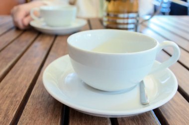 İki çay bardaklarından ve Fransız arkasındaki bulanık kadın masada, basın