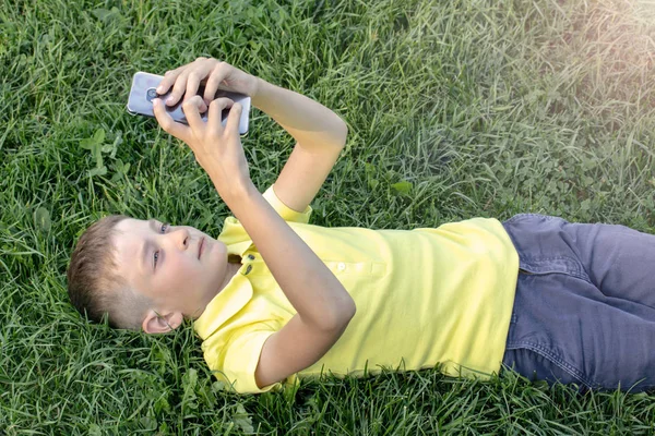 Niño Con Camisa Amarilla Con Teléfono Celular Teléfono Inteligente Acostado —  Fotos de Stock