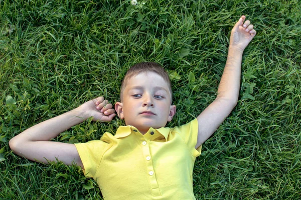 Ξέγνοιαστες Καυκάσιος Αγόρι Στο Κίτρινο Πουκάμισο Ξαπλωμένος Στο Γρασίδι — Φωτογραφία Αρχείου