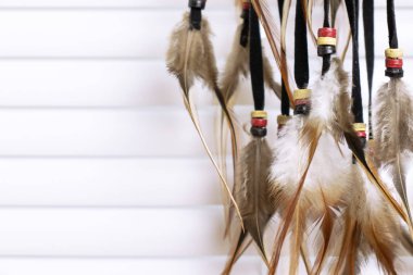 Rüya yakalayıcı tüyler konu ve boncuk ip asılı ile arka plan üzerinde beyaz pencere kör ediyor. Dreamcatcher el yapımı