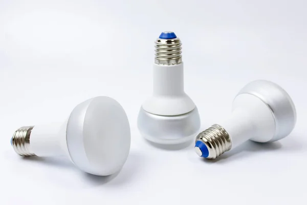 Three energy saving lamp with e27 sockets on white background.