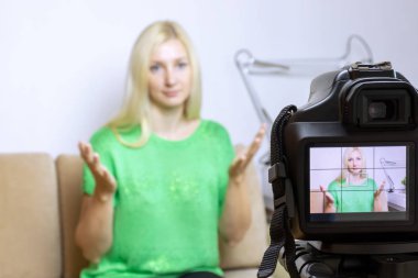 Fotoğraf, fotoğraf makinesi tripod üzerinde kamera Lcd ekranda genç kadın ve arka plan üzerinde bulanık sahne ile kapatın. Kadın video blogger vlog veya podcast, streaming online kayıt