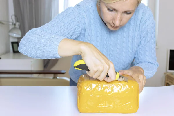 Kobieta Niebieski Sweter Rozpakowuje Rozpakowywanie Pomarańczowy Paczke Nożem — Zdjęcie stockowe