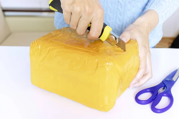 Una Mujer Jersey Azul Desempaca Desenvasa Paquete Naranja Con Tijeras — Foto de Stock