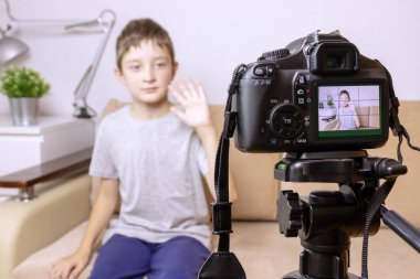 Fotoğraf, fotoğraf makinesi tripod üzerinde kamera Lcd ekranda bir çocuk ve arka plan üzerinde bulanık sahne ile kapatın. Erkek çocuk video blogger vlog veya podcast, streaming online kayıt.