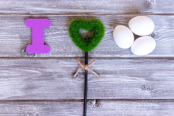 Sign I love eggs made of colorful letters, green grass heart and natural eggs, eco healthy food concept.