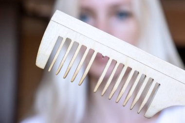 Onun elinde kırık tarak ile bulanık sarışın kadın.