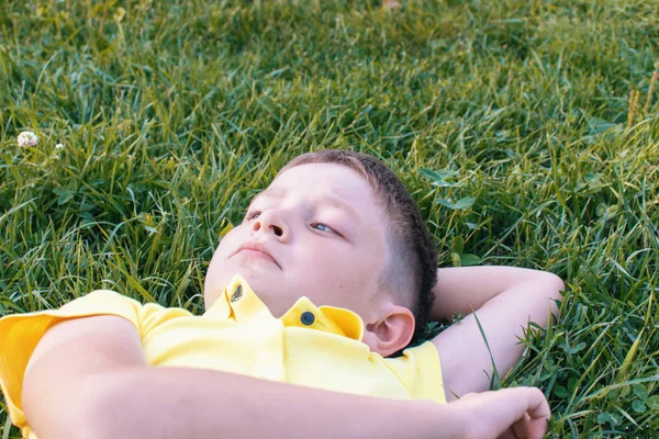 Ξέγνοιαστες Καυκάσιος Αγόρι Στο Κίτρινο Πουκάμισο Ξαπλωμένος Στο Γρασίδι — Φωτογραφία Αρχείου