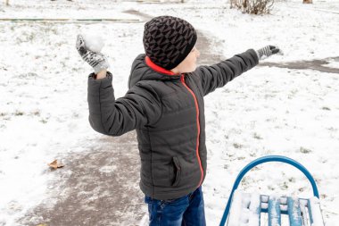 Beyaz çocuk sculpts kartopu, açık kış aktiviteleri, spor kavramı.