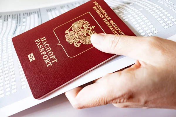 Hand holding russian passport and registration at the place of stay form.