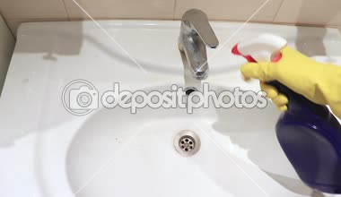 Silecek sprey ve köpük temizleyici yağmurlama tanınmaz halde kadında bir banyo musluk, lavabo ve su yıkama sarı lastik eldiven. Temizleme, silerek ve banyo lavabo yıkama