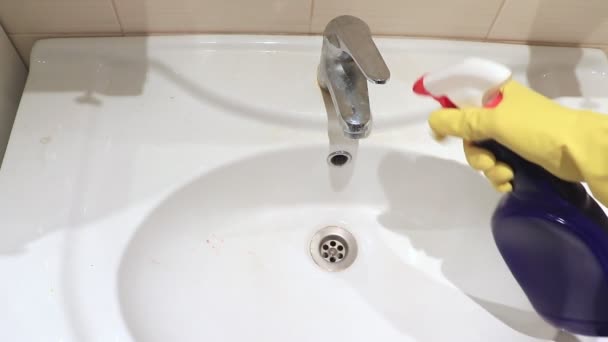 クリーン ワイパー噴霧および泡と散水バスルーム シンクと水タップを洗う黄色いゴム手袋で認識できない女性 クリーニング 拭くと浴室の流しを洗濯 — ストック動画