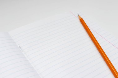 Beyaz bir arka plan üzerinde sarı kalem kopya alanı ile defter yakın çekim yaprak astarlı.