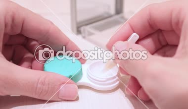 Kontakt lensler Cımbız kullanarak bir konteyner dışarı alarak eller kırpılmış