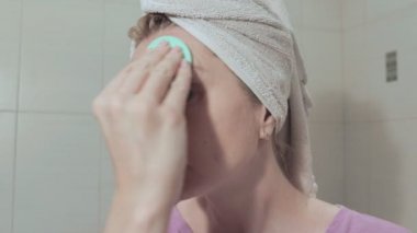 Orta yaş kadın onun baş telafi üzerinde bir havlu ile. Duş ve kavram makyaj