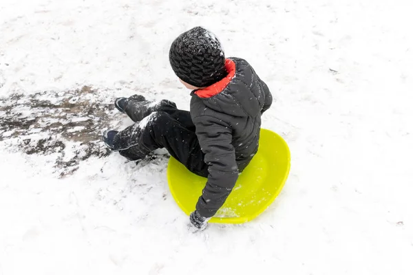 Chłopiec Siedmiu Lat Jeździ Slajd Górki Sankach Zielony Lód Koncepcja — Zdjęcie stockowe