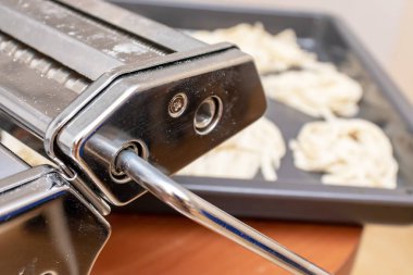 Ev yapımı şerit yumurta İtalyan makarna üzerine arka plan ile makarna ve mantı yapma fo yakın çekim hamur makinesi haddeleme.