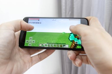 Moskova, Rusya - 08 Ocak 2018: bir smartphone online multyplayer oyun Mojang tarafından Minecraft ile holding eller.