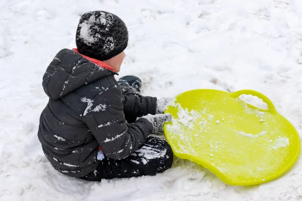 Boy Seven Years Old Sitting Snow Green Plastic Saucer Sled — Stock Photo, Image