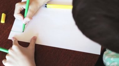 Resepsiyon ve resim sketches renkli marker ile beyaz kağıt üzerine oturan bir çocuk
