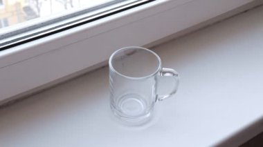 Kadın bir pencere pervazına şeffaf cam bardakta hazır kahve sabah brews.