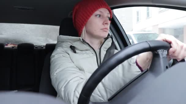 妇女在冬天衣衣和橙色编织的帽子驾驶汽车在冬天路 — 图库视频影像