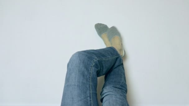 女性は、ジーンズの足上げと白い壁に対してリラックス ソックス — ストック動画