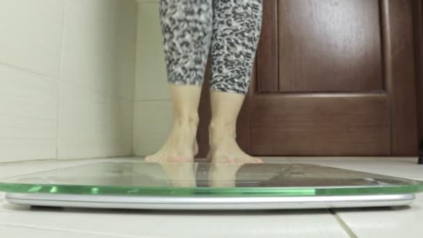 Γυναίκα γυμνα ποδια στέκεται στη ζυγαριά και ζύγιζε στο μπάνιο - δίαιτα και βάρος απώλεια έννοια — Αρχείο Βίντεο