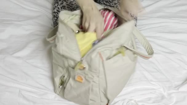 Mulher Sentada Uma Cama Abre Uma Bolsa Tirar Roupas Com — Vídeo de Stock