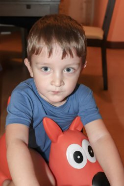 Onun oyuncak bir katta oturan kızgın ve ciddi küçük çocuk