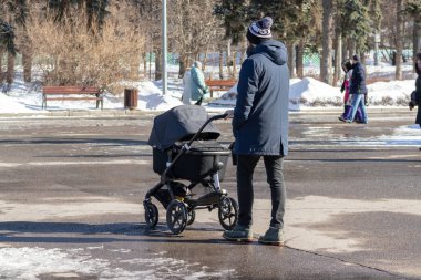Moskova, Rusya - 02 Mart 2019: Tek insan bebek arabası ile taşıma kış parkta yürüyor