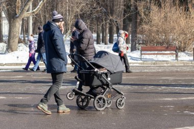 Moskova, Rusya - 02 Mart 2019: Tek insan bebek arabası ile taşıma kış parkta yürüyor