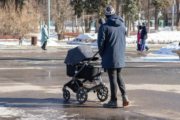 MOSCOU, RUSSIE - 02 MARS 2019 : Homme célibataire avec poussette bébé, promenades en calèche dans le parc d'hiver — Photo