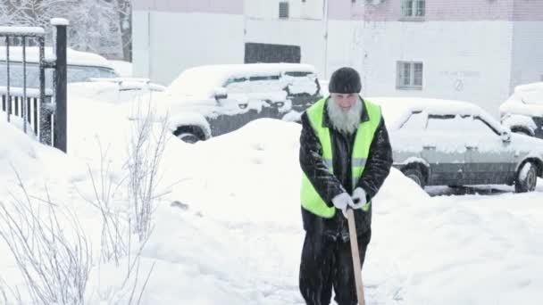 MOSCÚ, RUSIA - 25 DE FEBRERO DE 2019: Trabajador del servicio de mantenimiento elimina la nieve con una pala, pala - limpieza de calles después de la tormenta de nieve — Vídeos de Stock