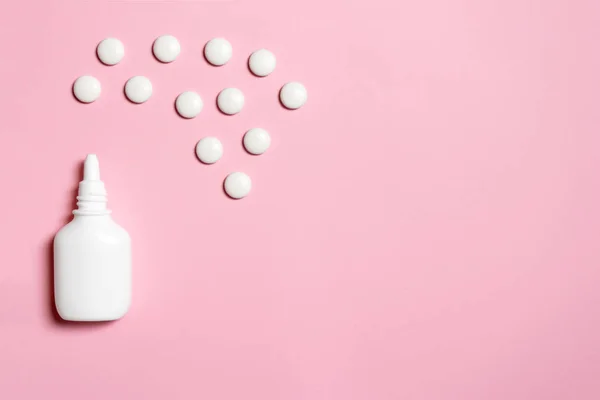 Spray nasale di plastica bianca con compresse su sfondo rosa sinusite, geniantrite, rinite e altre malattie del concetto di organi ENT — Foto Stock