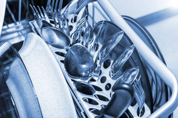 Lavavajillas de cerca, platos, cucharas de cubiertos zorros y cuchillos en una bandeja de plástico — Foto de Stock