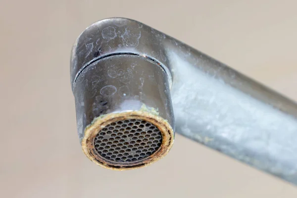Dirty faucet aerator with limescale, calcified shower water tap with lime scale in bathroom, close up